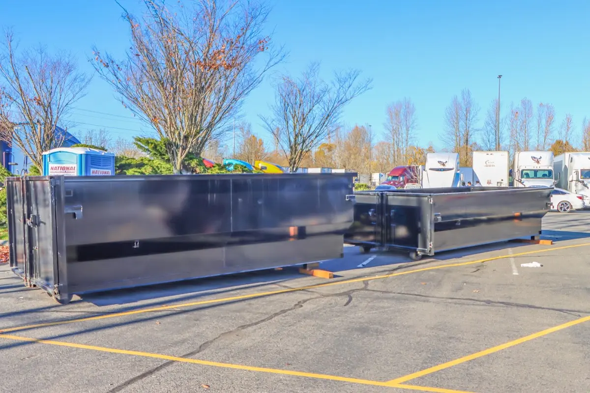 Professional dumpster rental service with roll-off container on residential driveway in Bridgetown